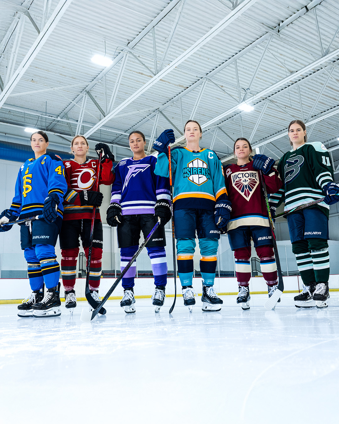 Six Professional Women's Hockey League players standing on their skates ...