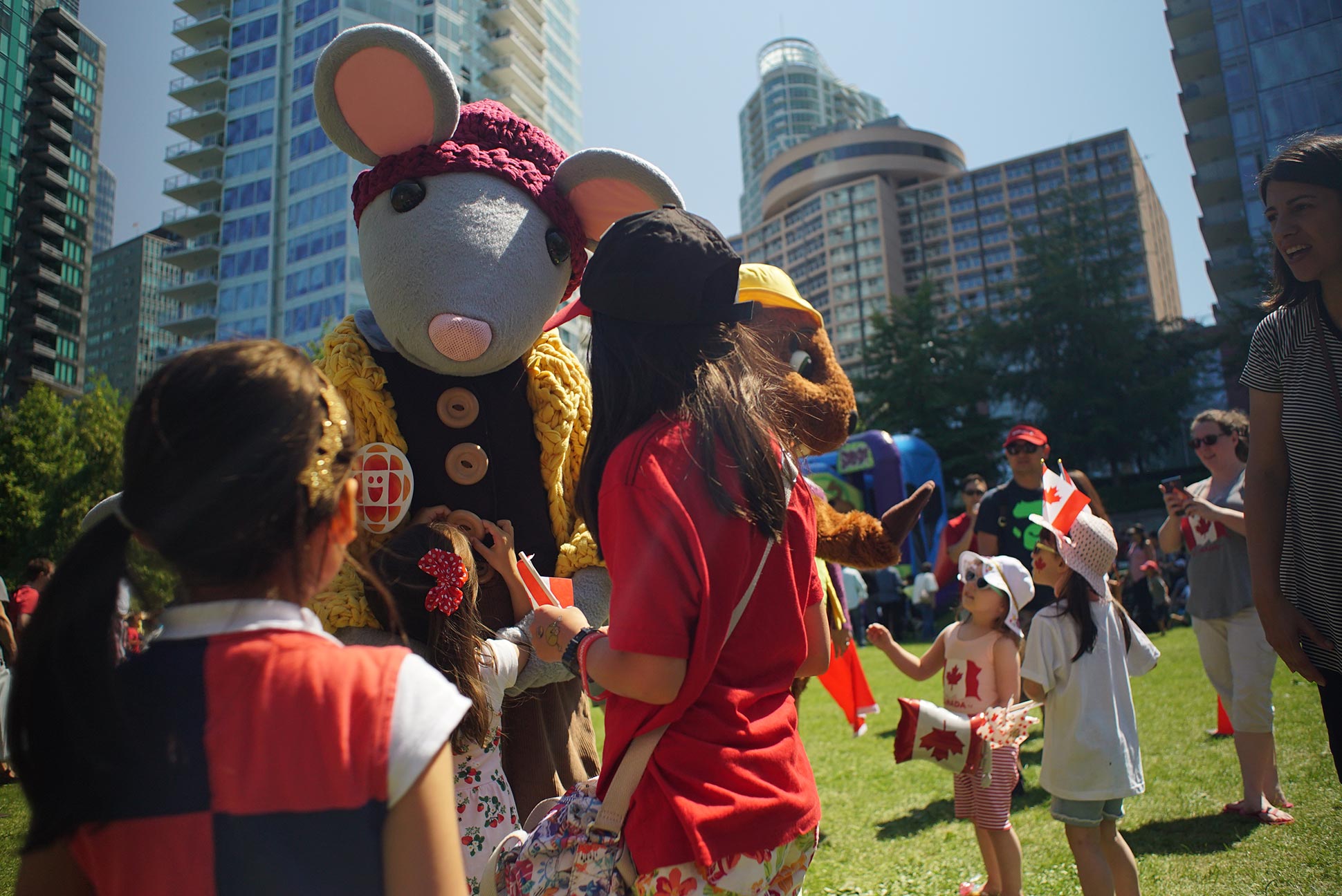A mouse and a beaver mascot meet children in a crowd